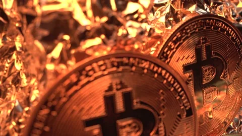 Three golden cryptocoins Bit coin rotate on the gold reflection surface. Macro Stock Footage 134523907