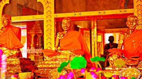 Three golden statues in a buddhist temple on a background of a lotus flower Video stock 38289657