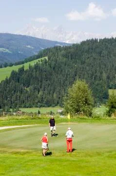 Three golfers on golf course Stock Photos