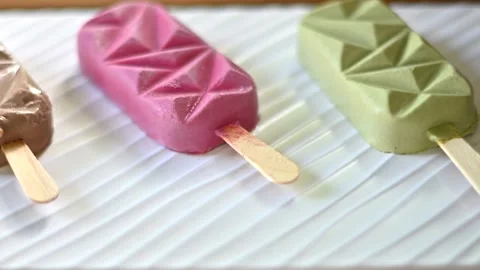 Three gourmet geometric popsicles arranged on white surface for refreshing .. Stock Footage 339395963