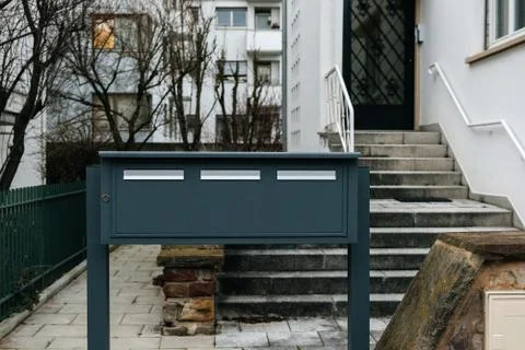 Three gray mailboxes in front of modern house Stock Photos