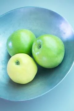 Three green apples on dish Stock Photos