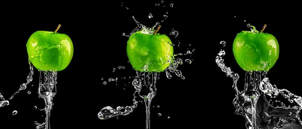 Three green apples on a fork in splashes of water on a black background Stock Photos