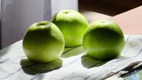 Three Green Apples On The Table On Sunny Day Stock Footage 154165453