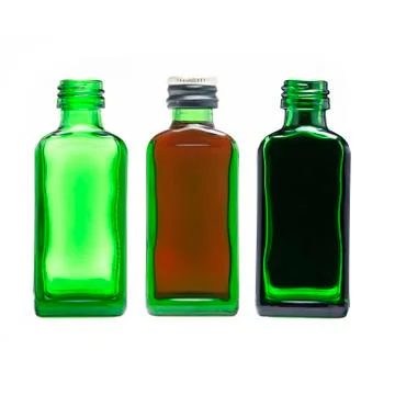 Three green bottles: empty, with brown liquid, with black liquid. For cosmeti Stock Photos