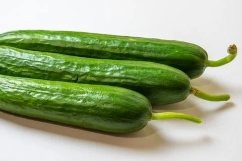 Three green fresh cucumbers on a white background Stock Photos
