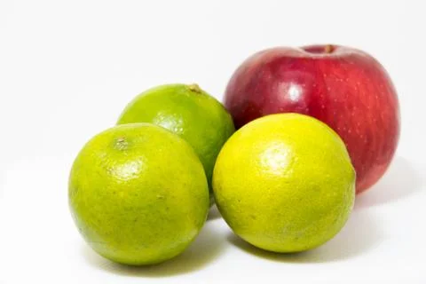 Three green lime one red apple Stock Photos