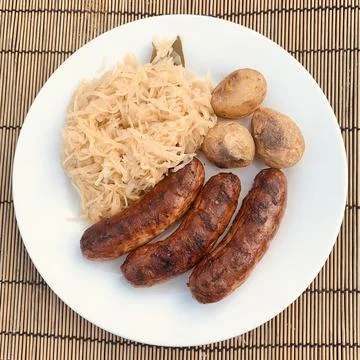Three grilled sausages with cabbage as an intermediate dish Stock Photos