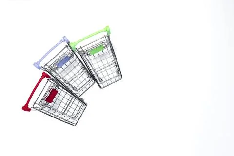 Three grocery baskets with colored handles on a light background top view. Stock Photos