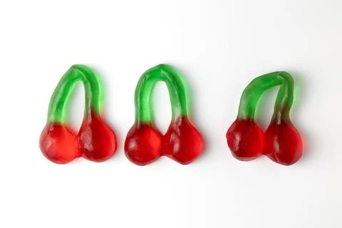 Three gummy cherries candy lying on white background Stock Photos