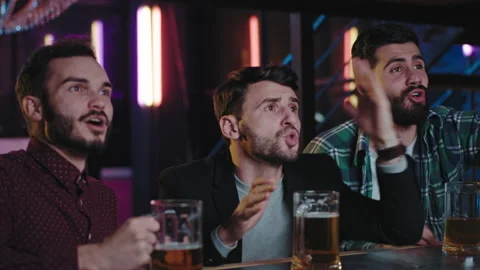 Three guys charismatic closeup to the camera football fans in a pub while Stock Footage 135917427