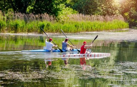 Three guys floating in a canoe on the river 写真素材