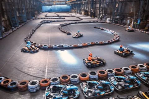 Three guys overtaking each other on an indoor karting track Stock Photos