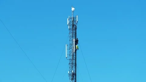 Three guys, supposedly workers, climbed a cell phone tower, hung on it, smoked Stock Footage 319130180