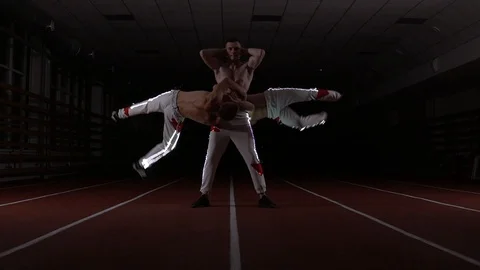 Three gymnasts and acrobats perform sports power stance Stock Footage 129472840