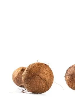 Three hairy coconuts on white background, copy space Stock Photos