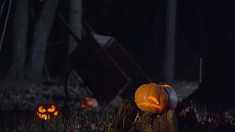 Three halloween jack-o-lanterns with candles lights Stock Footage 133709129