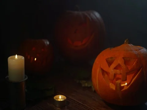 Three Halloween Pumpkin head lantern with burning candles on a black background Stock Footage 80250799