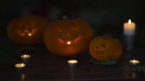 Three Halloween Pumpkins head lantern with burning candles on a black background Video stock 80251234
