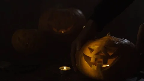 Three Halloween Pumpkins head lantern with burning candles on a black background Stock Footage 80267677