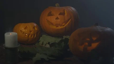 Three Halloween Pumpkins head lantern with extinct candles on a black background Stock Footage 80272068