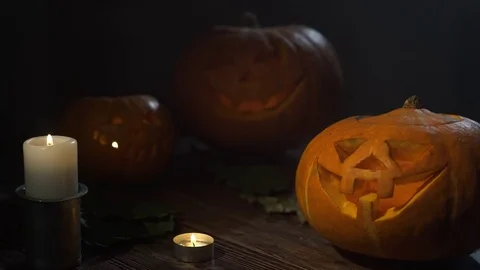 Three Halloween Pumpkins head lantern with burning candles on a black background Stock Footage 80275043