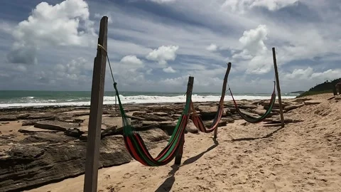 Three hammocks moving in the wind on the seashore. Stock Footage 166978252