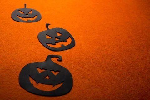Three hand-painted black pumpkins on an orange background Stock Photos