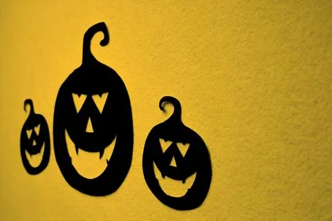 Three hand-painted black pumpkins on a yellow background Stock Photos