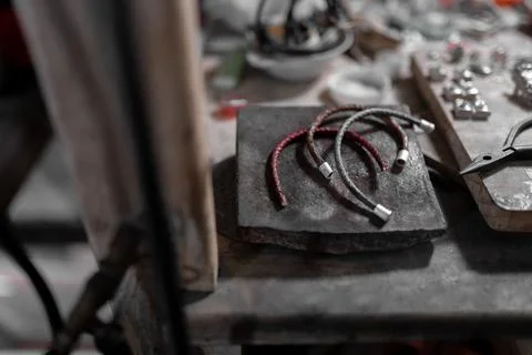 Three handmade bracelets are resting on top of the jeweler work table Stock-Fotos