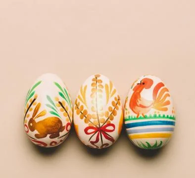 Three handmade Easter eggs on creamy background Stock-Fotos