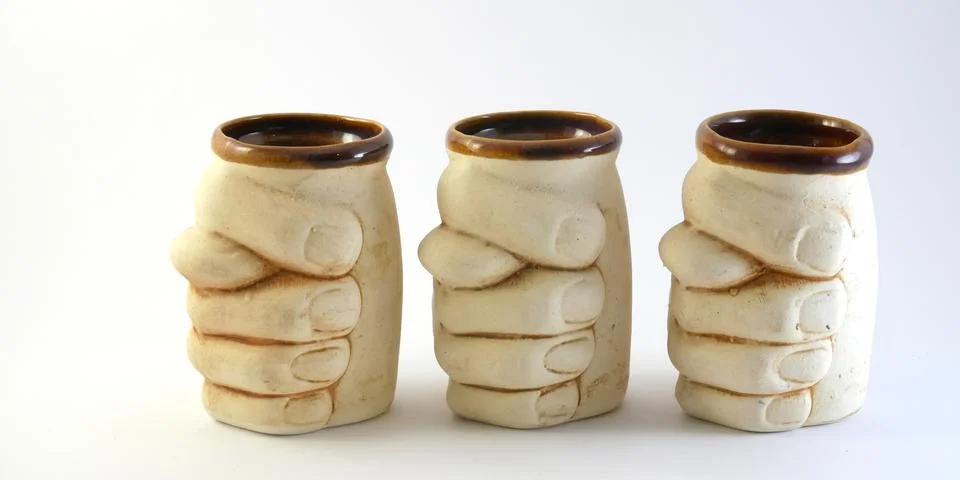 Three handmade glasses of clay with pattern on a white background. Stock Photos
