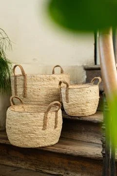 Three Handmade Woven Wicker Baskets on Rustic Wooden Stairs Foto stock