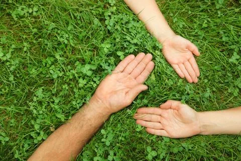 Three hands in grass Stock Photos