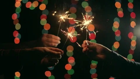Three hands holds a burning sparklers Stock Footage 81322794