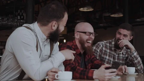 Three handsome young men are waching videos on the phone and laughing Stock Footage 85366615