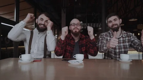 Three handsome young men are having good time at the modern cafe Stock Footage 85366638