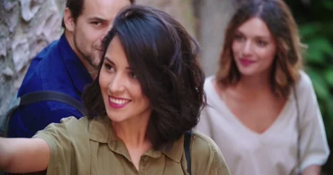 Three happy friends smiling while looking at smartphone camera for a selfie 動画素材 137935682