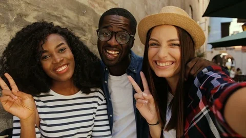 Three happy friends taking selfie in street of old city. Young positive people Stock Footage 81775475