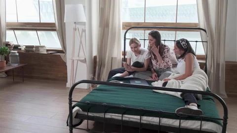Three happy girlfriends in the same pajamas spending time together at home. Stock Footage 131863564