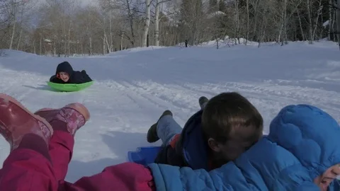 Three happy kids sledding slow motion Stock Footage 72249133
