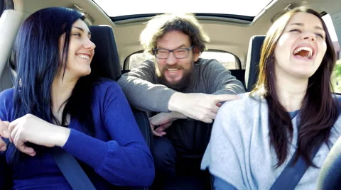 Three happy people having fun laughing in car while driving Stock Footage 60052734