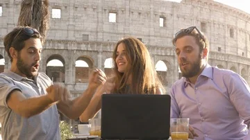 Three happy people working together on a project with laptop and tablet exulting Stock Footage 85596754