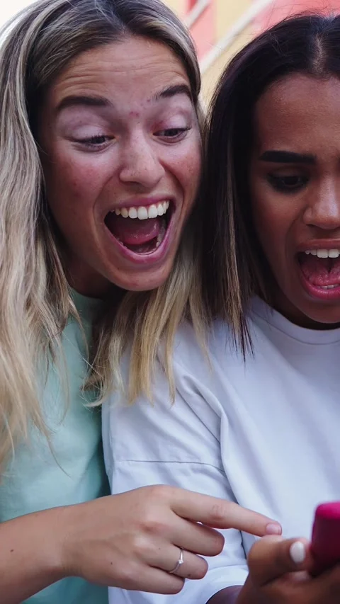 Three happy smiling female friends looking at the screen using mobile smart Stock Footage 316923853