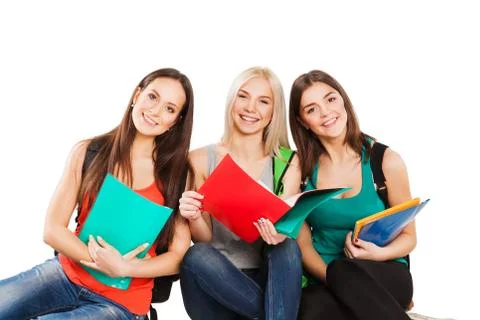 Three happy students sitting together with fun, while smiling and looking at Stock Photos