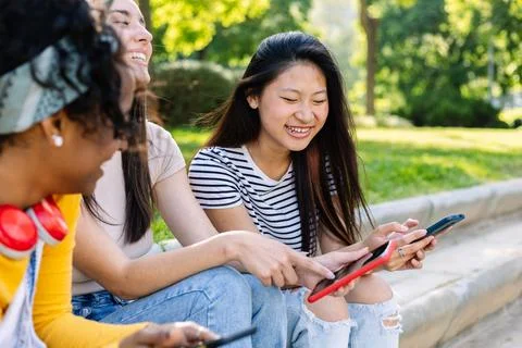 Three happy women using mobile phones at city street Stock Photos