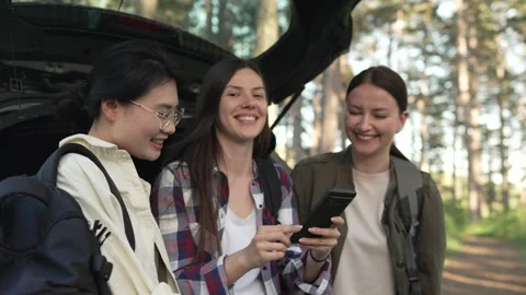 Three happy women using smart phone gps for hiking trail navigation Stock Footage 335844567