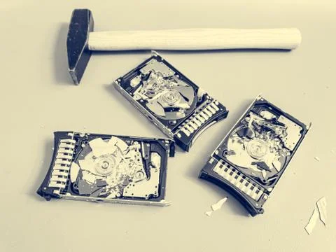 Three hard disk drives with shattered platter on a table. Stock Photos