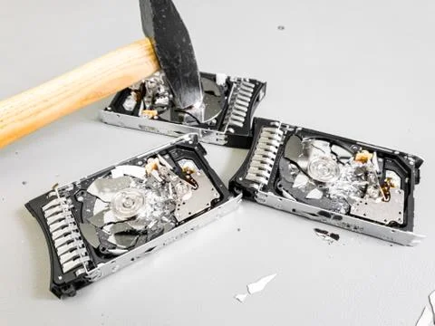 Three hard disk drives with shattered platter on a table. Foto stock