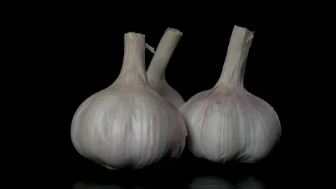 Three heads of garlic rotate on a black background, close-up Stock Footage 170696505